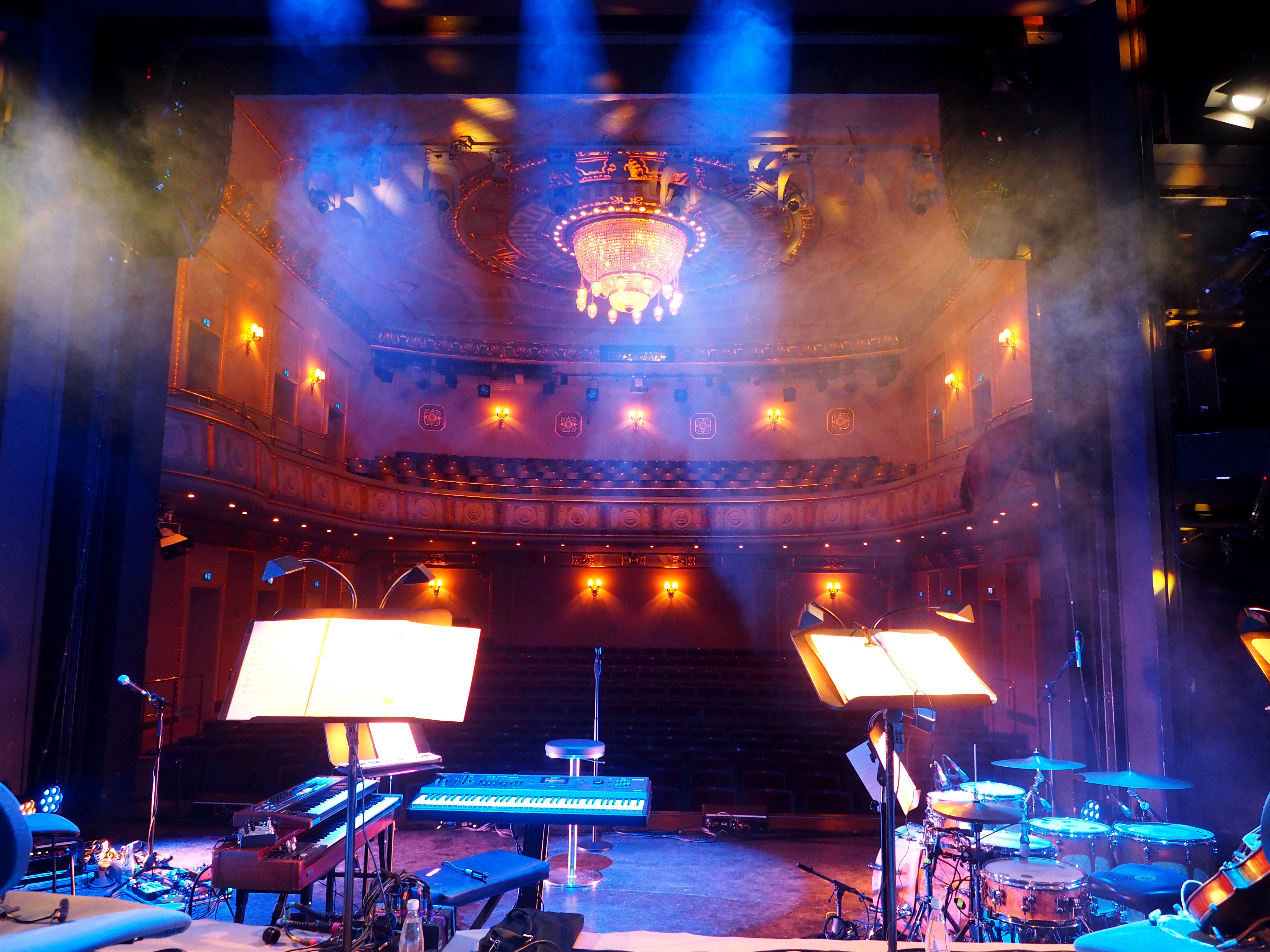 Rockkonzert mit Band und klassischen Instrumenten auf der Bühne eines Theaters.
